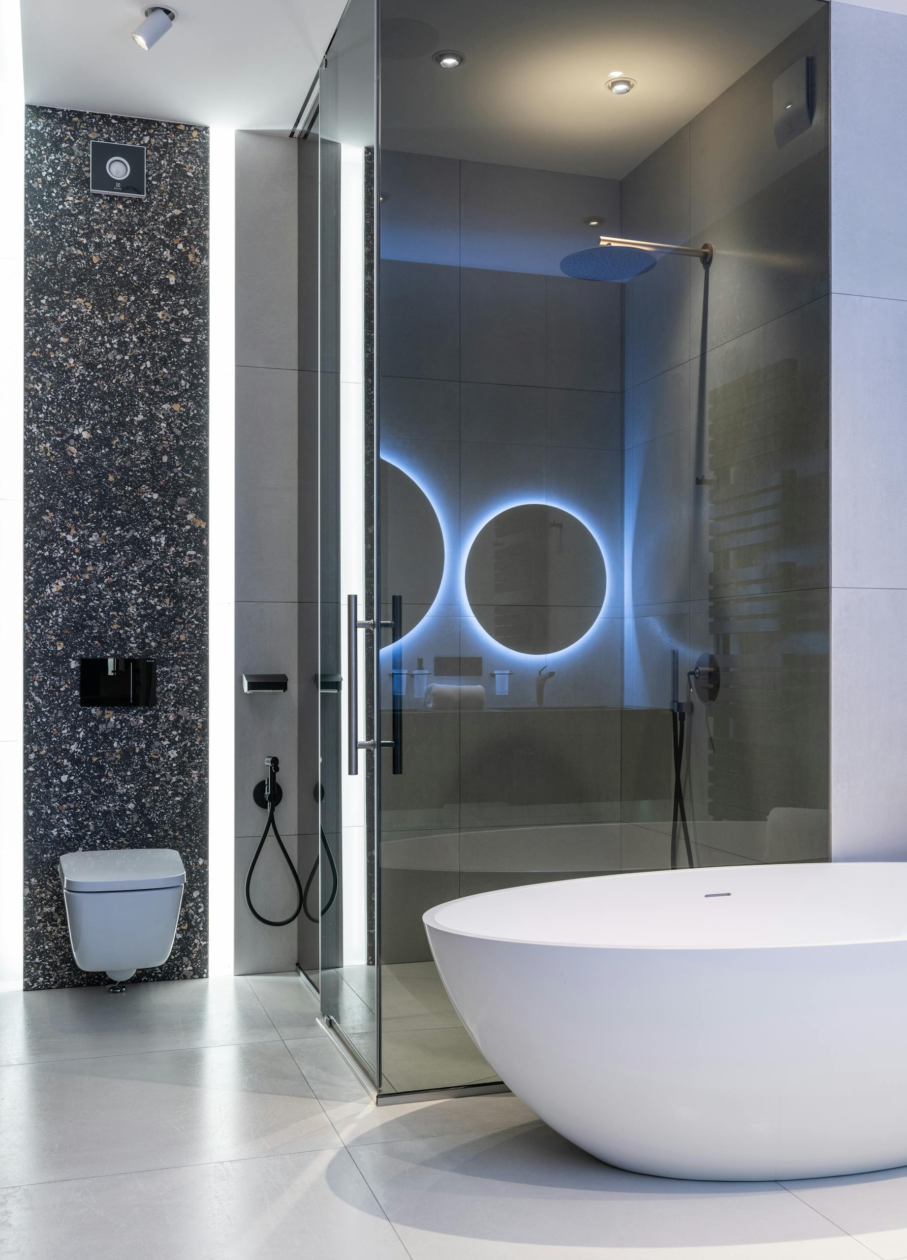 Sleek modern bathroom featuring a freestanding tub and illuminated shower area.