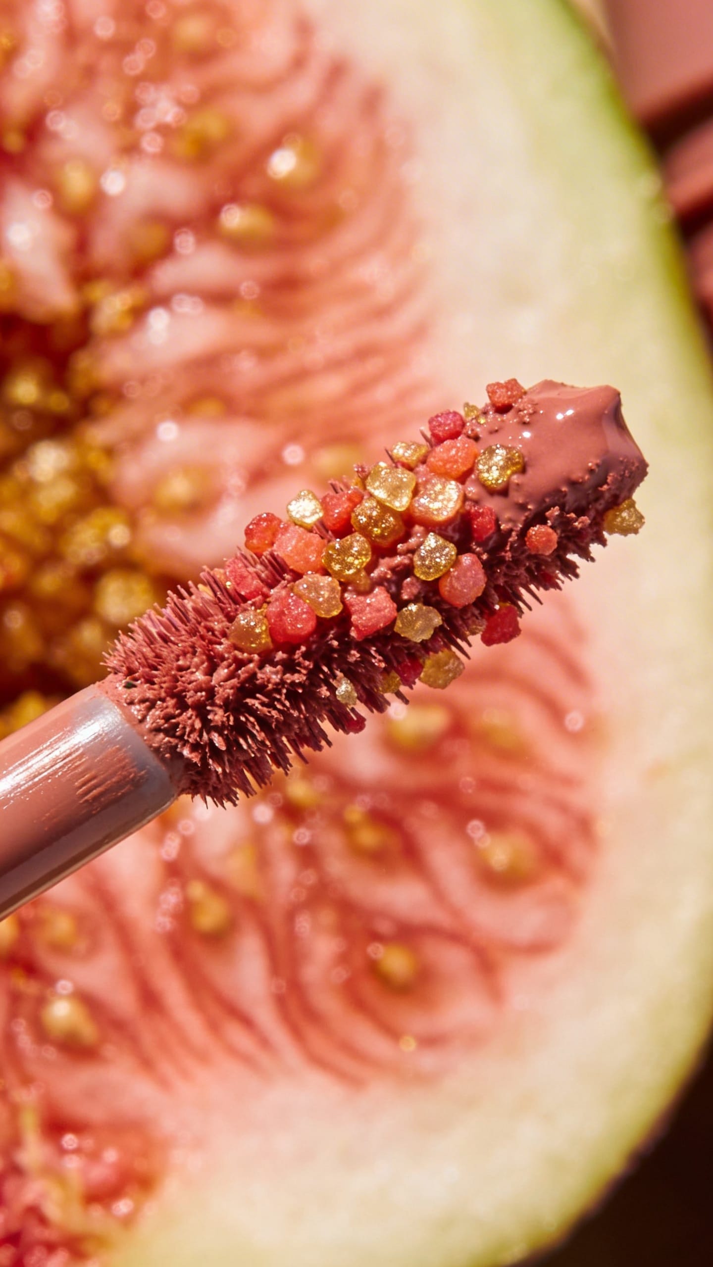 Vegan mascara wand with visible fruit pigments, macro shot